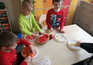 Dzieci z zapałem kroją owoce na sałatkę