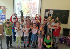 Grupa dzieci z oddziału zerówkowego prezentująca owoce