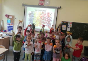 Grupa dzieci z oddziału zerówkowego prezentująca owoce