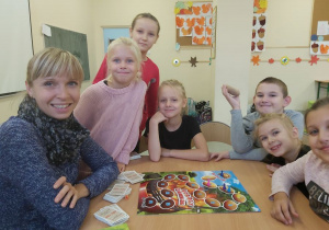 Pani Ania wraz z dziećmi gra w gry planszowe