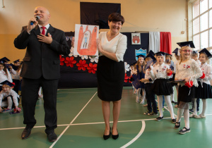 Pani Burmistrz prezentująca swój portret-w tle grupa dzieci.