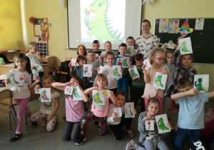 Dzieci z zerówki wraz z pokolorowanym portretem Dinka - maskotki programu