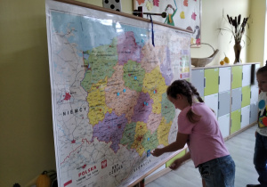 Dziewczynka odnajdująca na mapie miejsce pobytu Misia Kropka