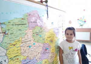 Dziewczynka pokazująca na mapie miejsca pobytu Misia Kropka