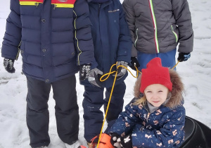 Koleżeńskie zdjęcie zadowolonych dzieci w czasie zabawy na śniegu
