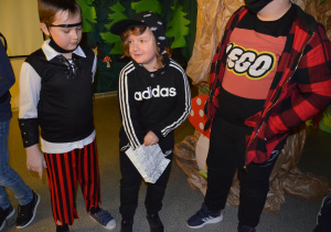 Patryk losuje swoje zadanie, Kacper i Kacperek spoglądają na niego z zaciekawieniem